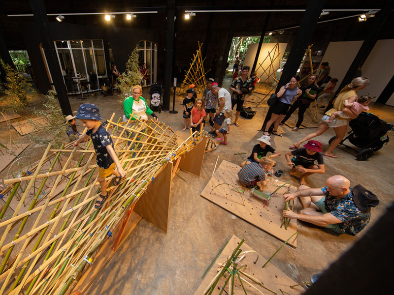 Children climbing a bamboo structure inside the Tanks Arts Centre