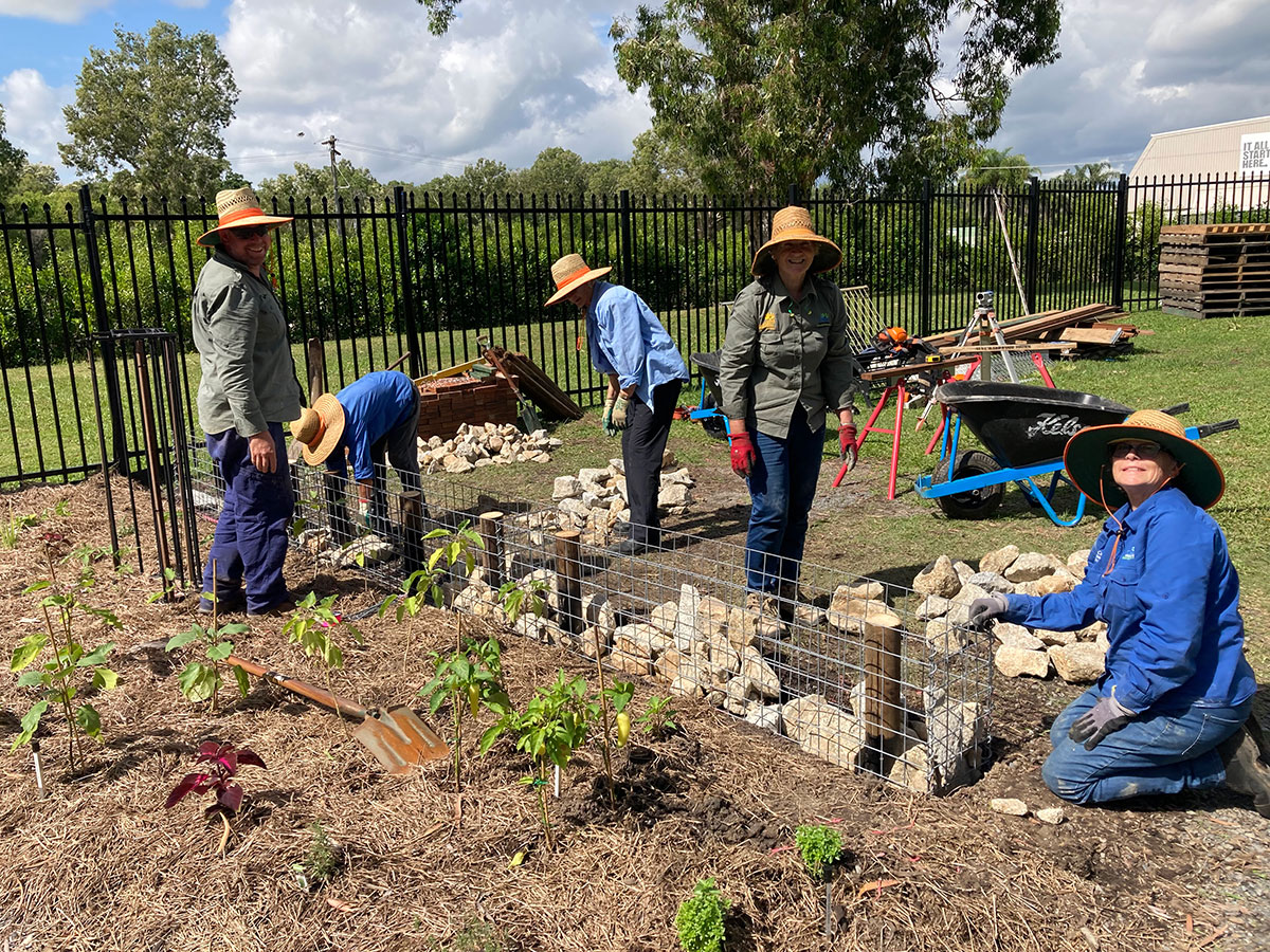 Five volunteers creating a bench seat from gabion cages at a Green Space workshop