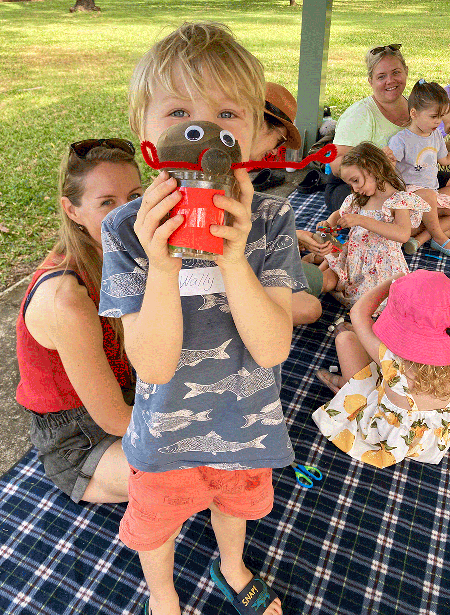 Young child proudly holding coconut man in front of face