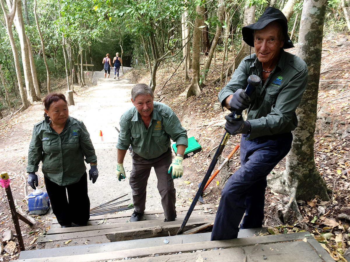 Three volunteers replacing broken timber step on Arrow Trail