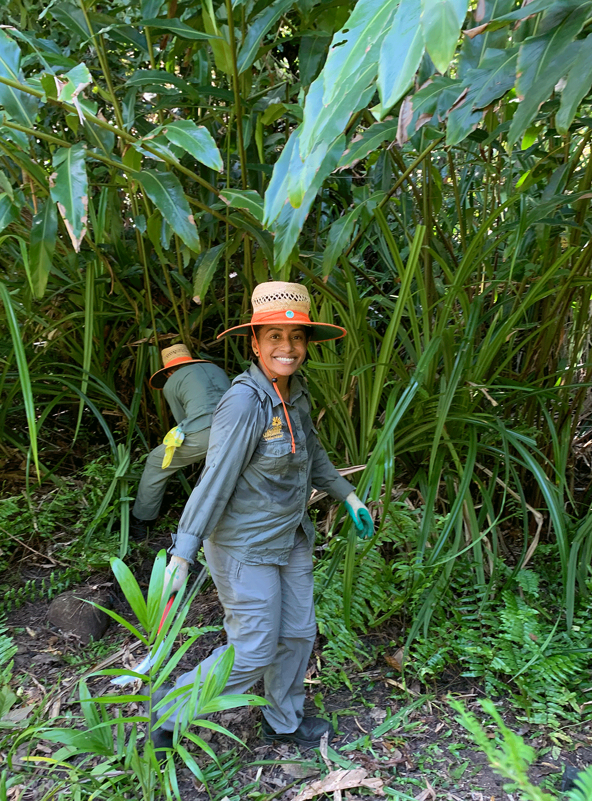 Smiling volunteer admiring a newly cleared area of undergrowth 