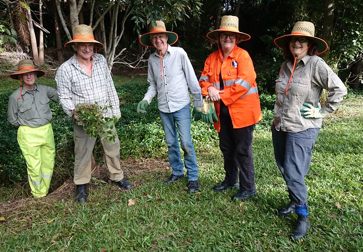 Five community members post in front of newly weeded area